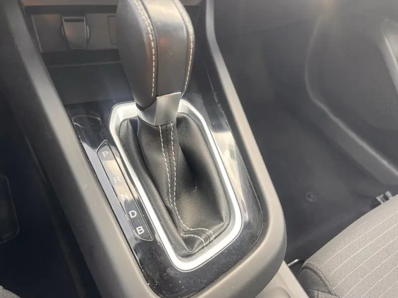 Le levier de vitesse automatique en cuir noir avec surpiqûres blanches dans le Renault Arkana blanc perle.