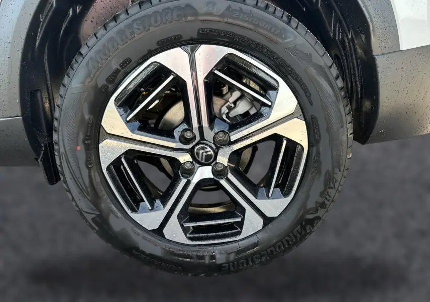 Gros plan sur la jante alu bicolore noire et argentée du côté avant droit du Citroën C3 Aircross blanc.