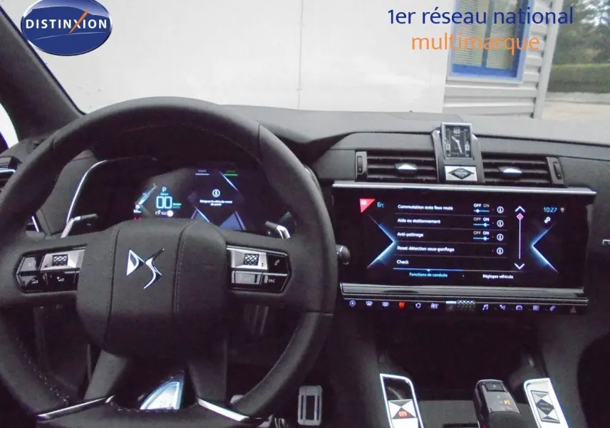Intérieur du DS7 Crossback E-TENSE 2021, vue du tableau de bord avec volant compact et écran tactile central allumé.