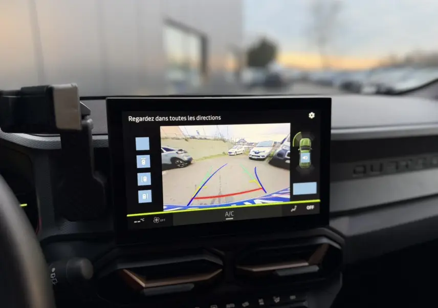 Écran tactile intérieur montrant la caméra 360° du Dacia Duster Beige Sandstone en marche arrière.