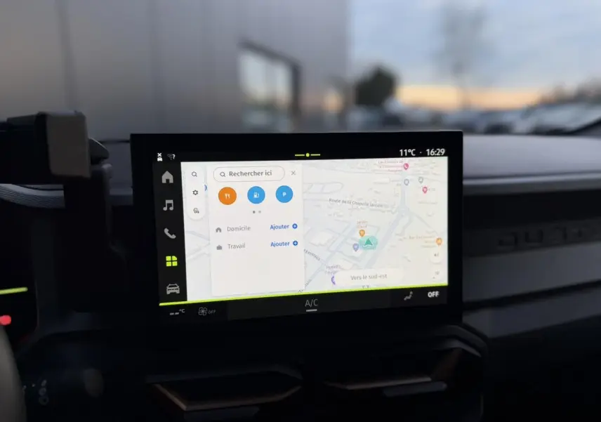 Vue intérieure centrée sur l'écran tactile 10 pouces du tableau de bord du Dacia Duster beige sandstone 2025.