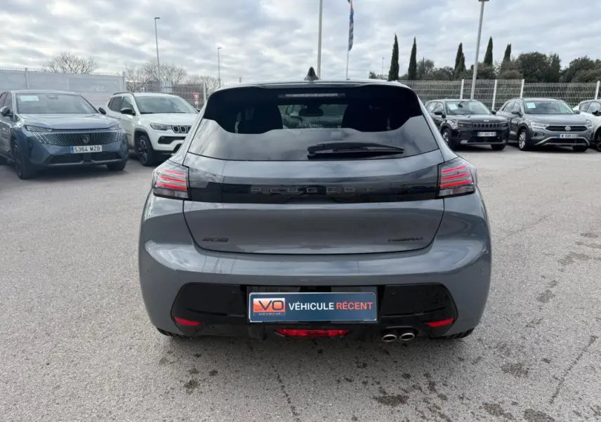 Vue arrière d'une Peugeot 208 Hybrid 145 gris métallisé avec feux LED et double sortie d'échappement visible.