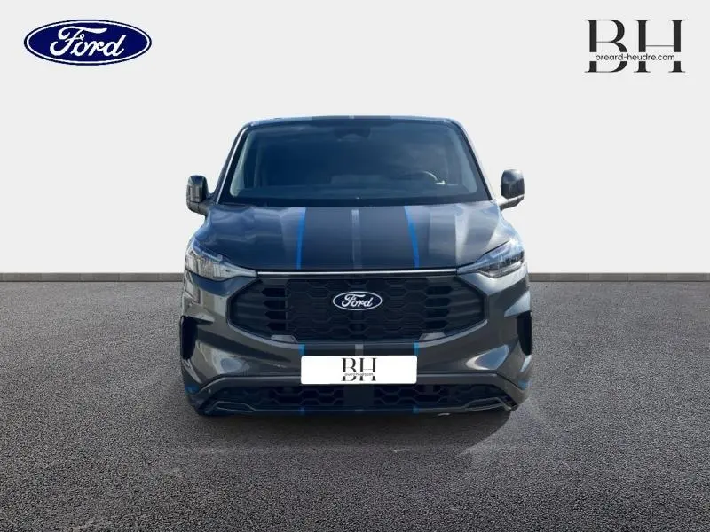 Vue avant du Ford Transit Custom Fourgon gris Magnetic métallisé avec bandes bleues sport sur le capot et calandre noire.