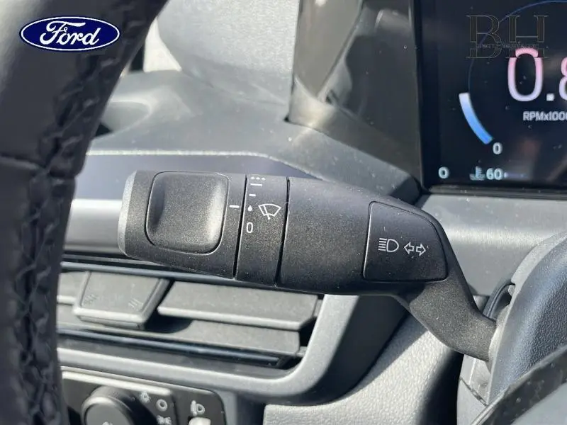 Gros plan sur la commande de clignotants et essuie-glaces du Ford Transit Custom gris à l'intérieur du tableau de bord.