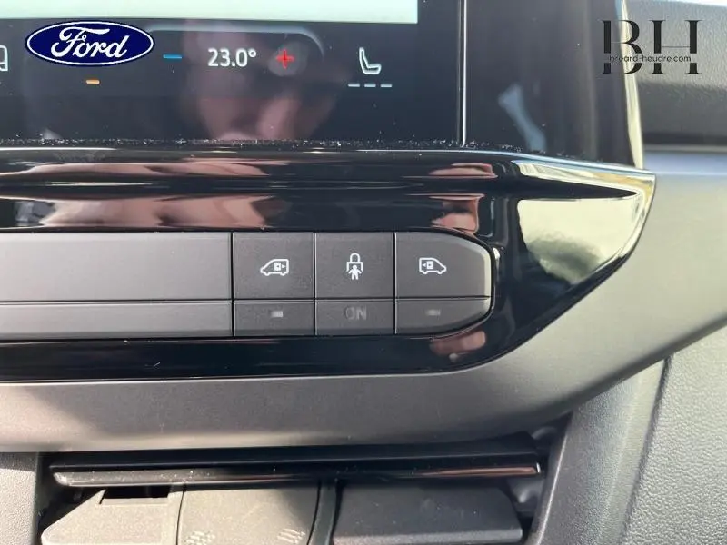 Détail du tableau de bord noir brillant du Ford Transit Custom 2026 avec commandes de portes coulissantes et verrouillage central.