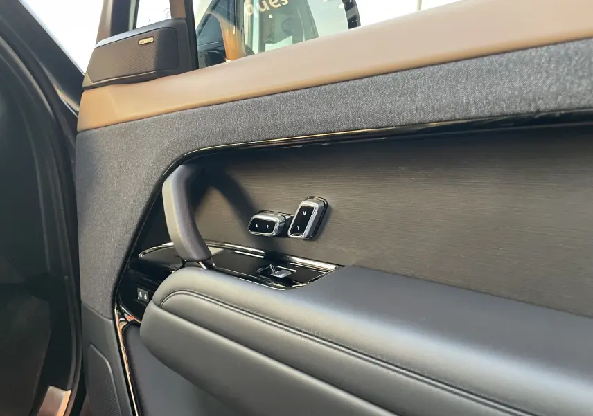 Détail de la porte côté gauche du Range Rover Sport 2023, avec commandes mémoire siège et garniture noire élégante.