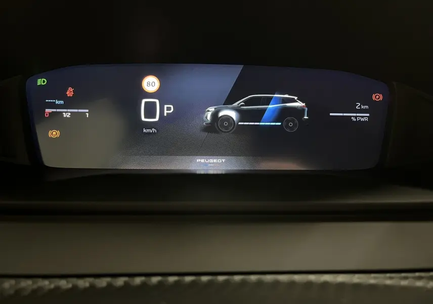 Tableau de bord numérique du Peugeot 2008 hybride, affichant une vue latérale stylisée du SUV en gris avec indicateurs de vitesse et énergie.