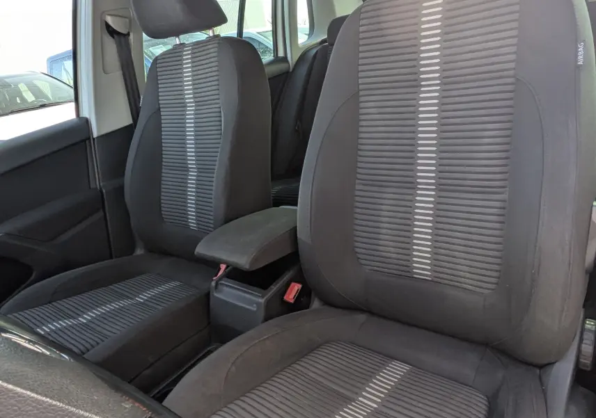 Vue intérieure du Volkswagen Tiguan 2010 montrant les sièges avant en tissu noir avec motifs gris.