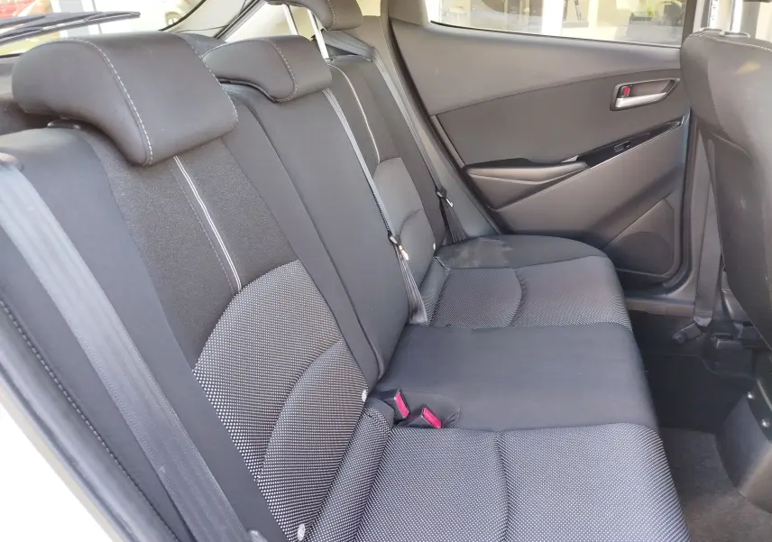 Vue intérieure côté droit des sièges arrière en tissu gris foncé de la Mazda2 2018 Snowflake White Pearl Mica.