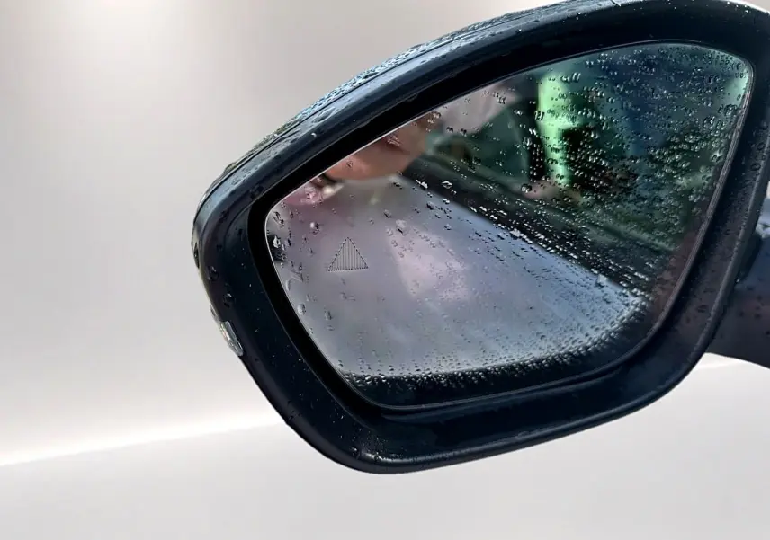 Rétroviseur extérieur côté droit de Citroën C3 Aircross blanc 2026 avec gouttes de pluie et signal d'angle mort visible.