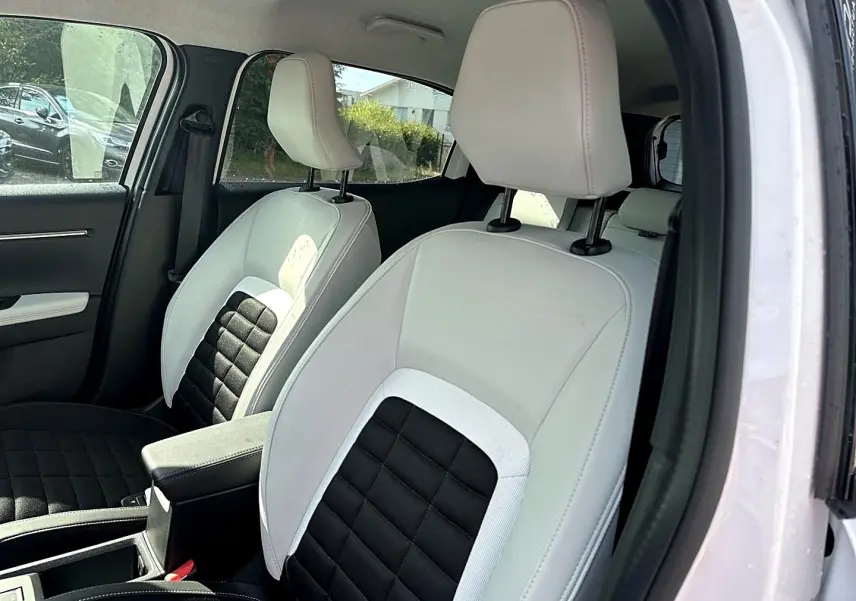 Intérieur de la Citroën C3 Aircross blanc, vue côté droit sur les sièges avant bicolores noir et blanc avec accoudoir central.