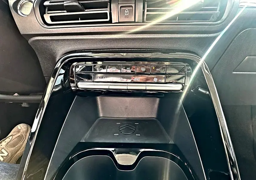 Vue rapprochée de la console centrale noire du Citroën C3 Aircross 2026 avec commandes climatisation et bouton start visible.