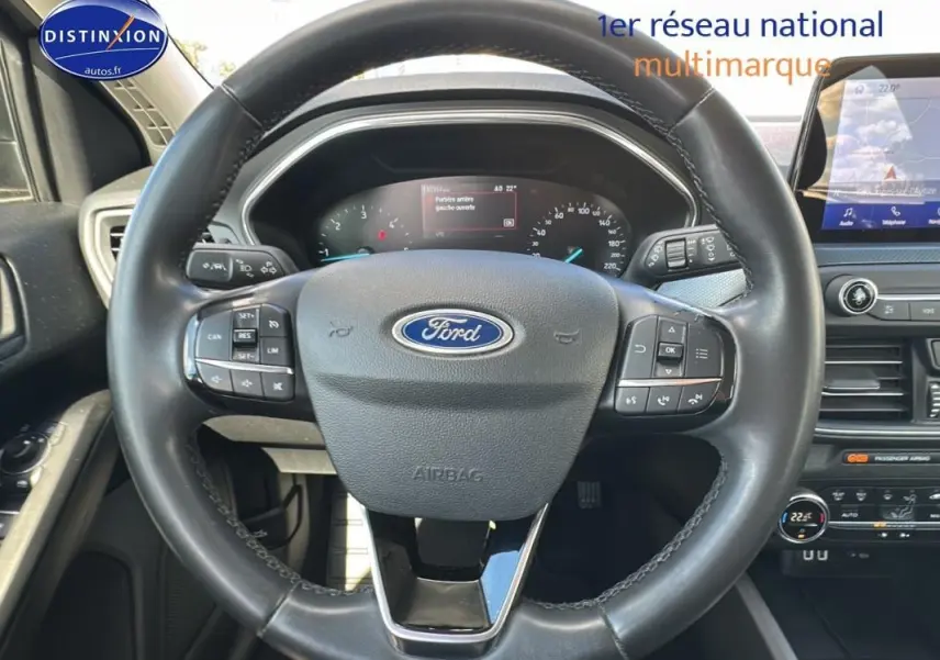 Vue rapprochée du volant noir de la Ford Focus Active 2021 avec commandes intégrées et tableau de bord numérique.