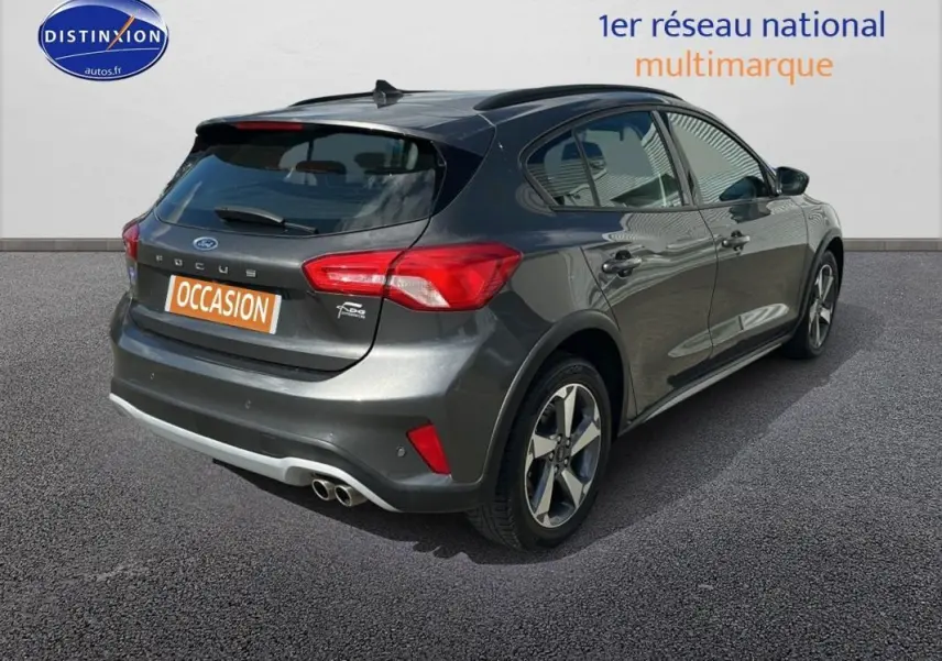 Vue 3/4 arrière droite d'une Ford Focus Active gris foncé avec barres de toit et jantes alliage 17 pouces.