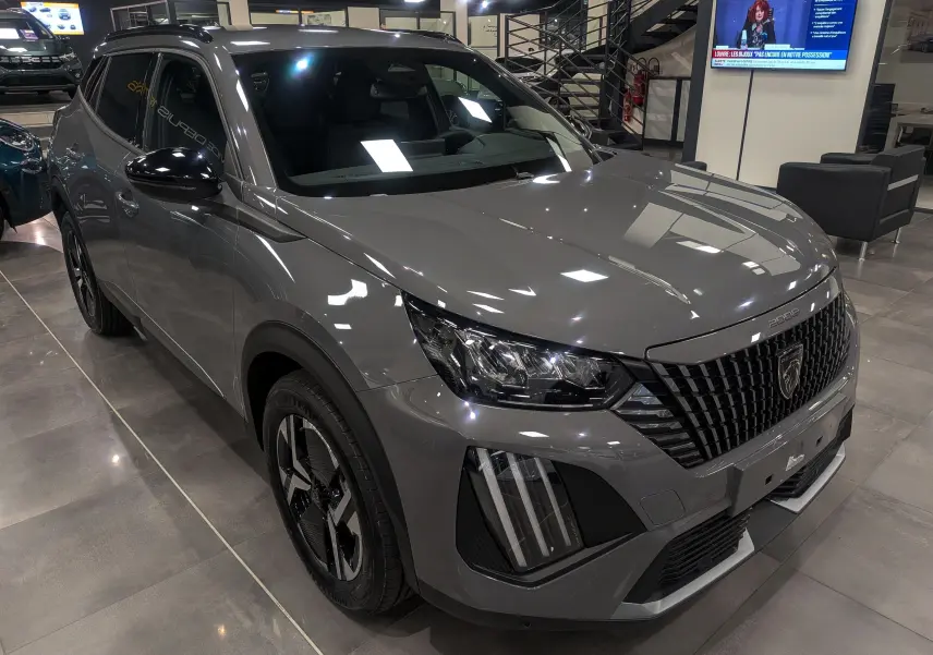 Peugeot 2008 Hybrid 145 gris Sélénium en 3/4 avant droit, avec calandre noire et feux LED distinctifs.