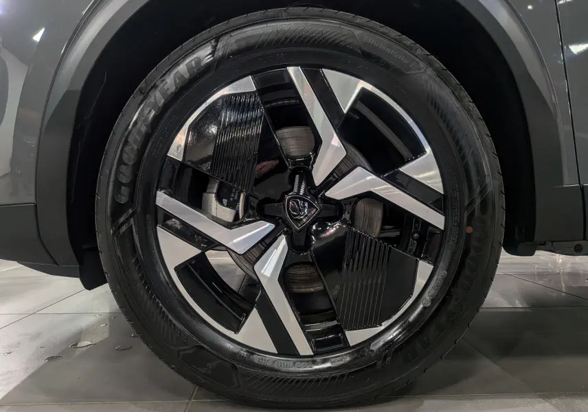 Gros plan sur la jante avant droite bicolore noir et argent du Peugeot 2008 Hybrid 145 e-DCS6 gris Sélénium 2025.