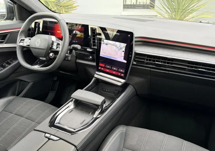 Vue intérieure côté conducteur du Renault Austral 2025 avec tableau de bord numérique et écran tactile central vertical.