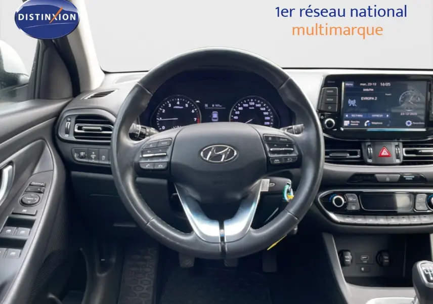 Vue intérieure centrée sur le volant et le tableau de bord du Hyundai i30 SW 2022 avec écran tactile et commandes au volant.