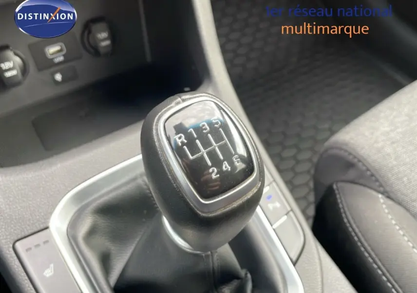 Le levier de vitesses manuel en gros plan dans l'habitacle du Hyundai i30 SW blanc, avec sellerie tissu noire visible.