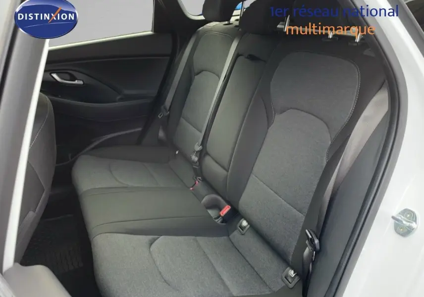 Vue intérieure côté droit montrant la banquette arrière en tissu gris d'une Hyundai i30 SW blanc atlas 2022.