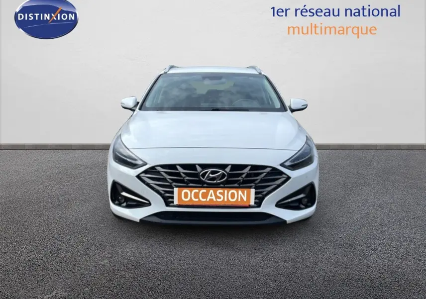 Vue avant d'une Hyundai i30 SW 1.5 T-GDI 160CH SMART blanche Atlas avec calandre noire et phares LED.