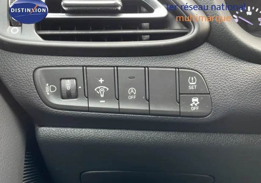 Gros plan sur les commandes de réglage d’éclairage et d’assistance au conducteur dans un Hyundai i30 SW blanc Atlas de 2022.