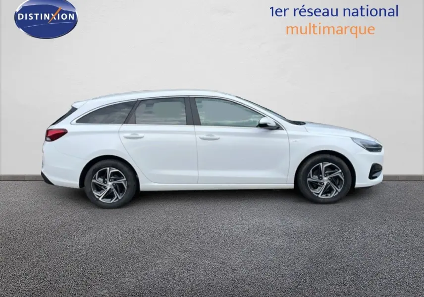 Profil droit d'une Hyundai i30 SW 1.5 T-GDI 160CH SMART blanche Atlas, avec jantes alliage et vitres teintées.