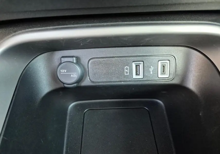 Vue rapprochée de la console centrale du Jeep Avenger noir 2024 montrant prises USB et prise 12V.