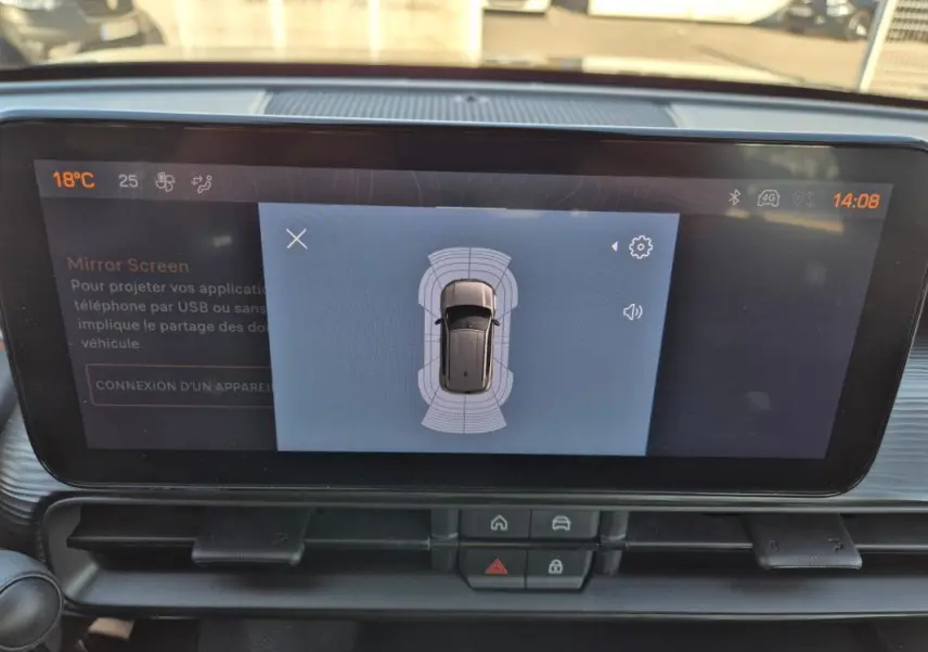 Vue rapprochée de l’écran central du Jeep Avenger 2024 noir, affichant l’aide au stationnement autour du véhicule.