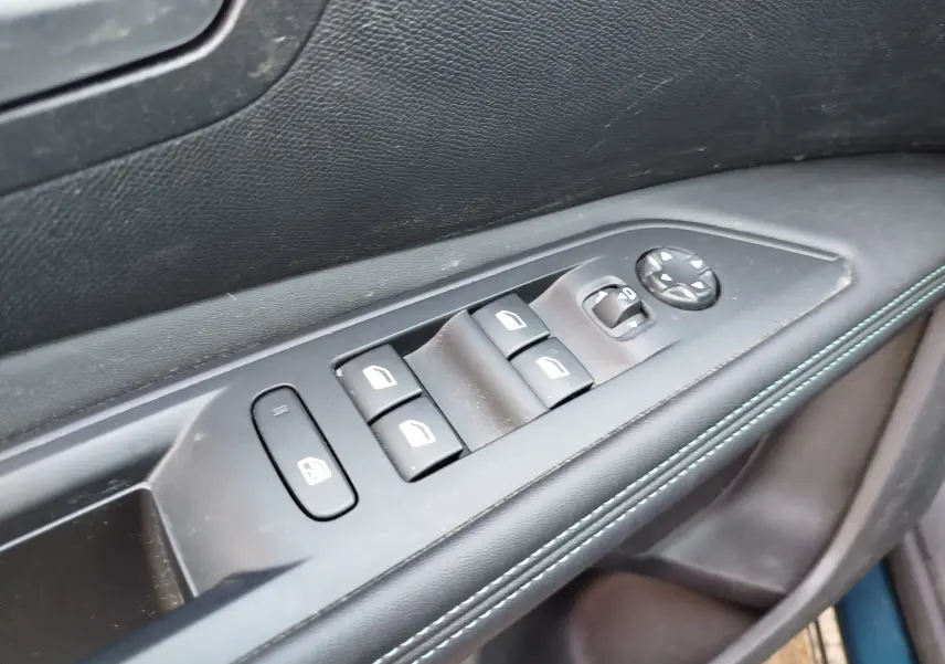 Gros plan sur les commandes des vitres et rétroviseurs côté conducteur de la Peugeot 3008 Hybrid 225ch Allure bleu Célèbes.