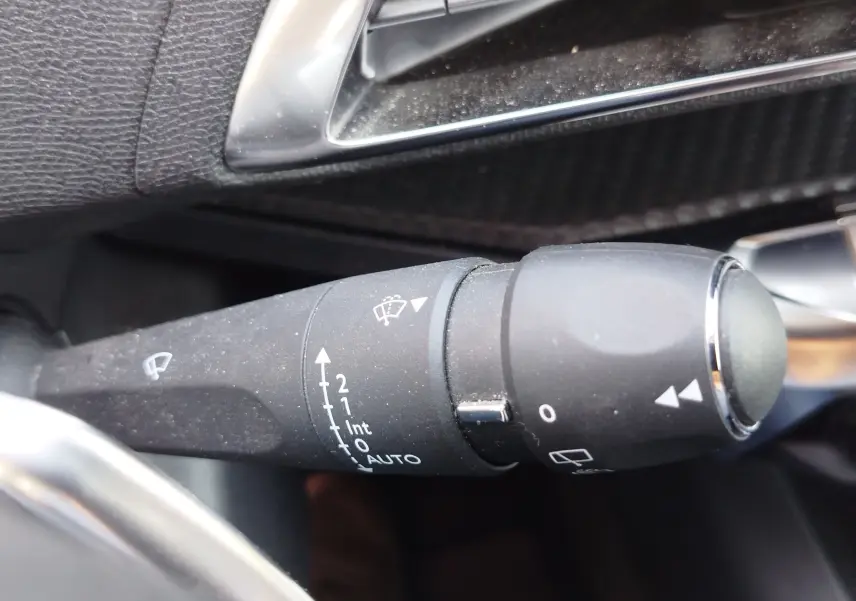 Gros plan sur la manette de commande des essuie-glaces dans l'habitacle d'un Peugeot 3008 bleu Célèbes 2022.
