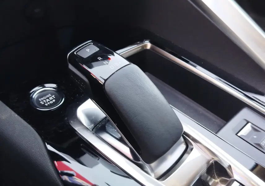Gros plan sur la commande de boîte automatique noire et grise du Peugeot 3008 Hybrid 225ch Allure 2022 avec bouton start/stop visible.