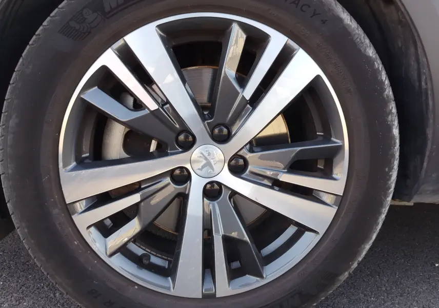 Gros plan sur la jante alliage bicolore du Peugeot 3008 Hybrid 225ch, avec logo lion au centre.
