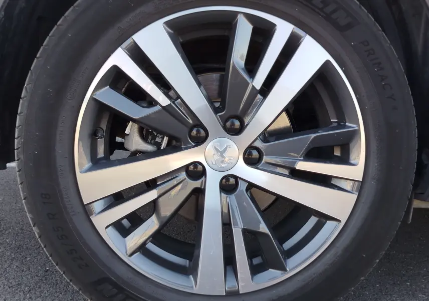Gros plan sur la jante alliage bicolore argent et gris du Peugeot 3008 Hybrid 225ch, avec logo lion au centre.
