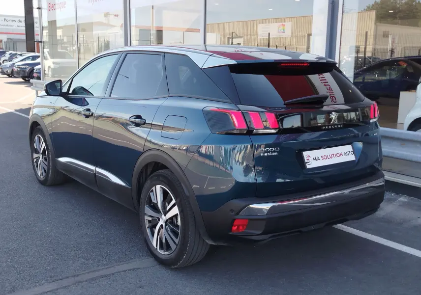 Peugeot 3008 hybride rechargeable bleu Célèbes vue 3/4 arrière droit, feux arrière allumés et jantes alliage.