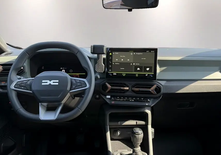 Vue intérieure frontale du tableau de bord du Dacia Bigster 2026 avec volant multifonction et écran tactile central.