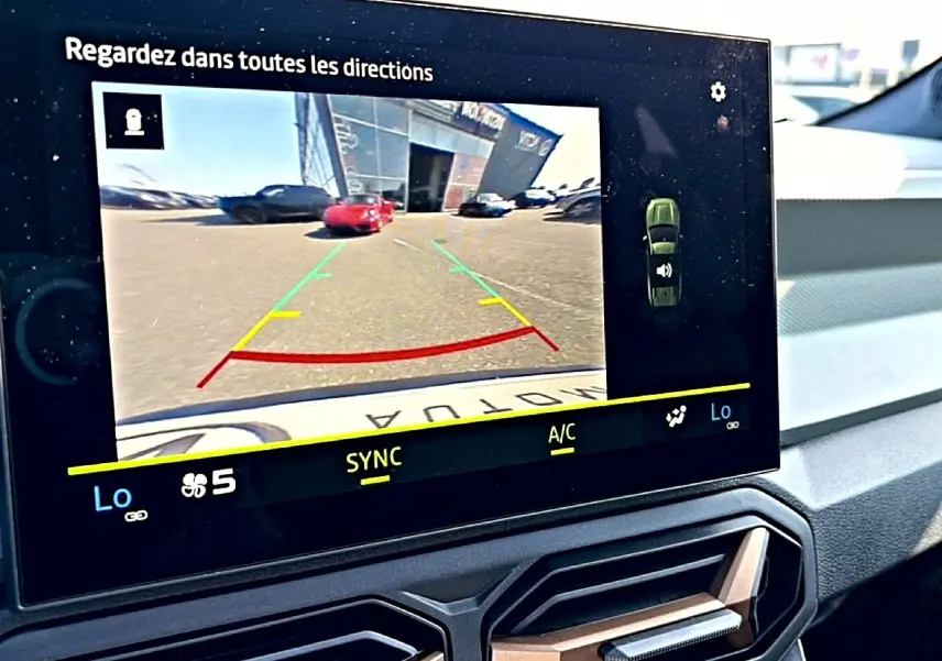Écran tactile intérieur du Dacia Bigster blanc montrant la caméra de recul avec guidage de trajectoire coloré.