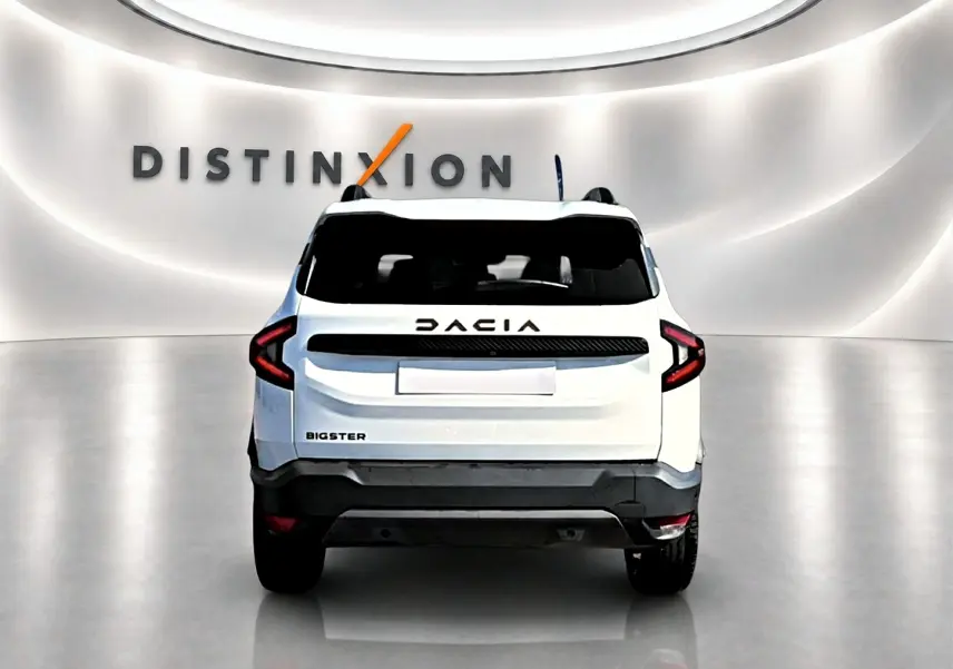 Vue arrière d'un Dacia Bigster blanc avec feux arrière en forme de C et logo DACIA noir sur fond blanc.