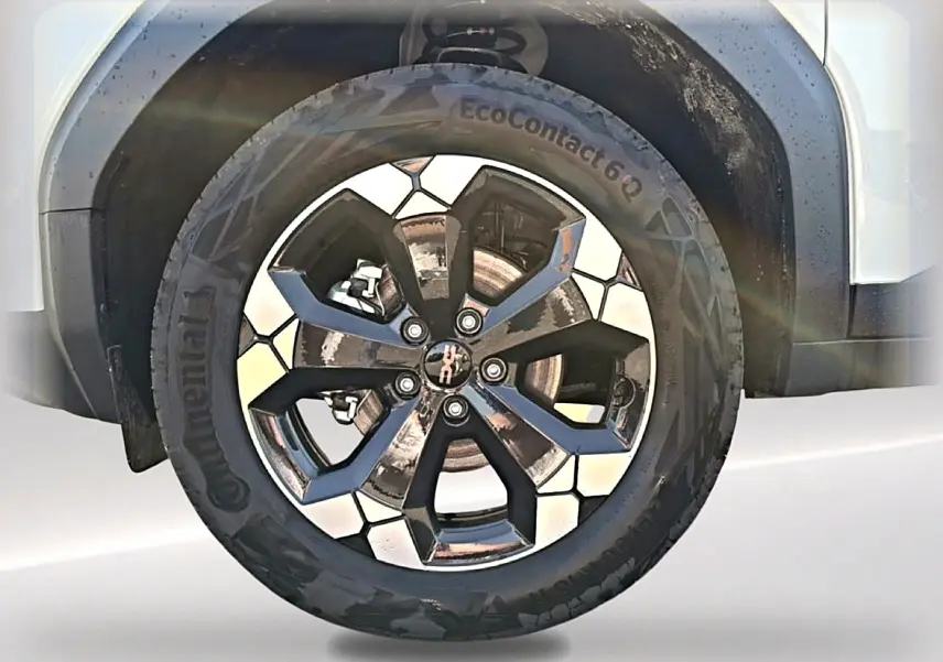 Gros plan sur la roue arrière droite blanche d’un Dacia Bigster 2026 avec jante alu noire au design hexagonal.