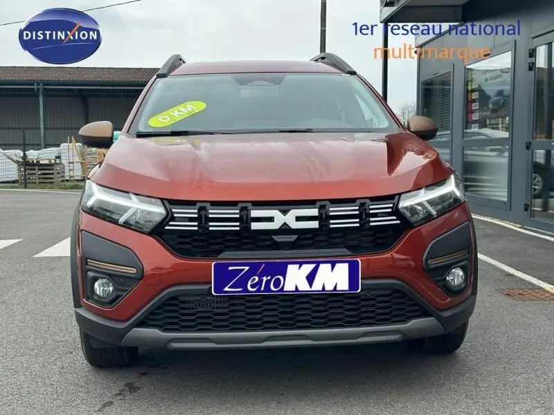 Vue avant d'un Dacia Jogger 2024 brun Terracota métallisé avec calandre noire et phares LED allumés.