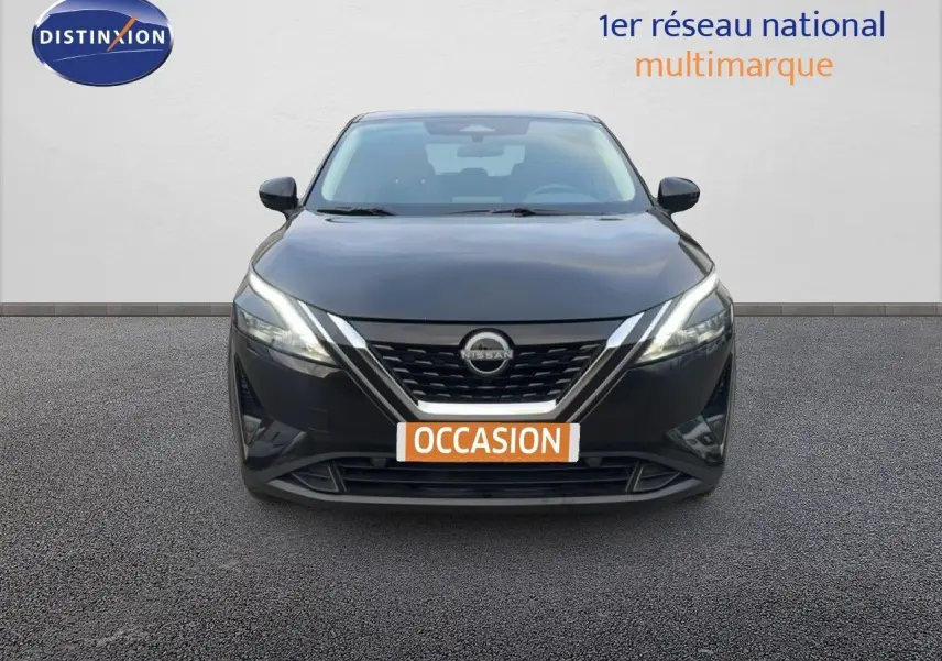 Vue avant d'un Nissan Qashqai noir métal 2023 avec calandre chromée et phares LED allumés.
