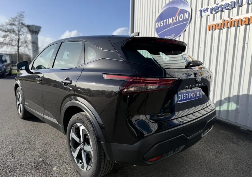 Vue 3/4 arrière droite du Nissan Qashqai noir métal 2023 avec feux arrière LED et jantes alliage bicolores.