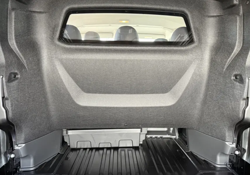 Vue intérieure de la cabine approfondie du Renault Trafic noir, montrant la cloison séparatrice et les sièges arrière.