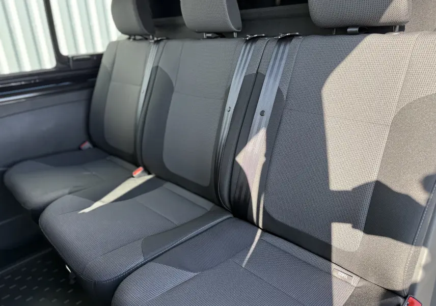 Vue intérieure rapprochée des sièges arrière en tissu gris foncé du Renault Trafic Cabine Approfondie L2H1 2025.