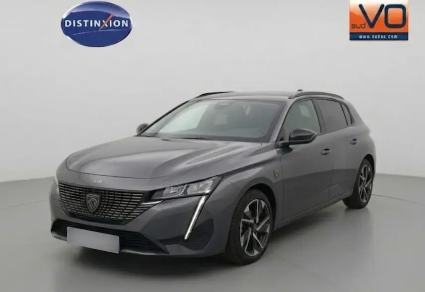 Peugeot 308 Hybrid gris vue 3/4 avant droit, avec calandre noire distinctive et jantes alliage 17 pouces.