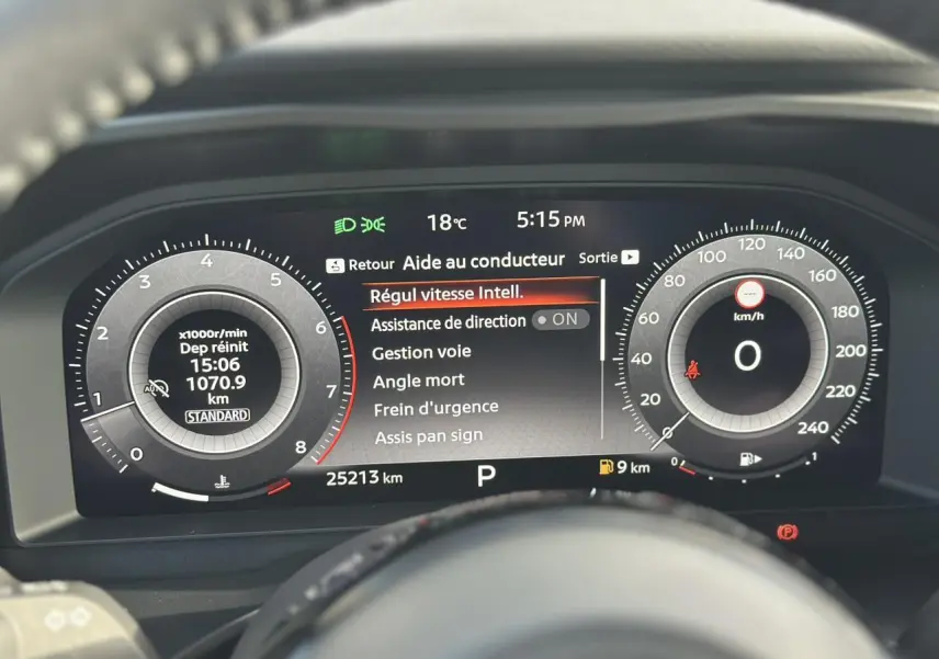 Tableau de bord numérique du Nissan Qashqai 2025 affichant les aides à la conduite et compteurs en vue frontale.