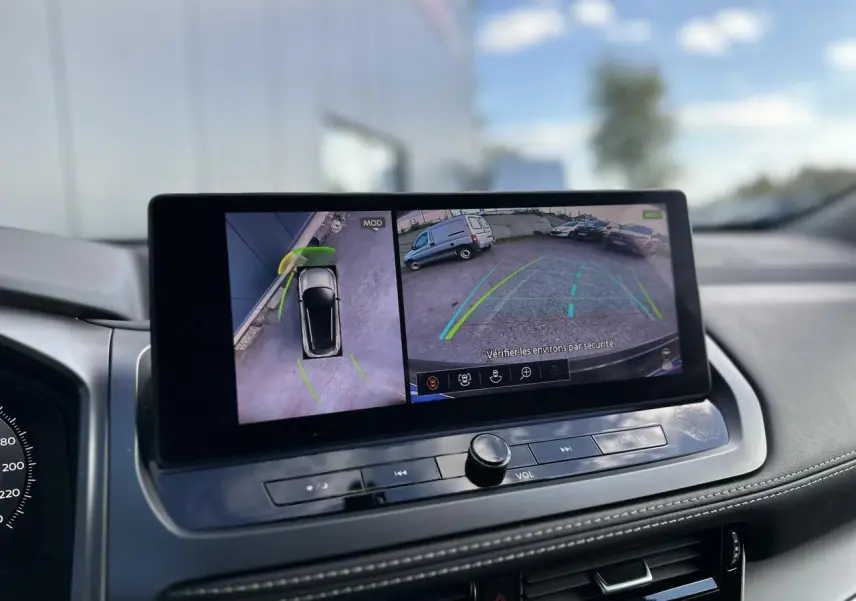 Écran central du Nissan Qashqai 2025 affichant la caméra de recul et la vue à 360° en intérieur noir.