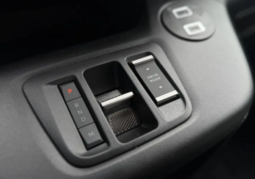 Gros plan sur la console centrale noire du Citroën Berlingo Multispace avec commandes de boîte auto et sélection du mode de conduite.