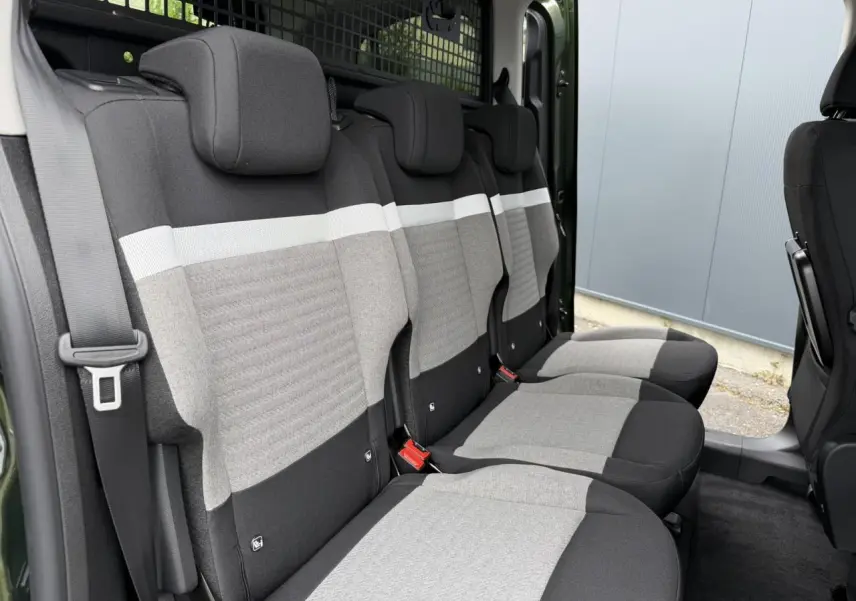 Vue latérale intérieure des trois sièges arrière gris clair et noir du Citroën Berlingo Multispace Vert Sirkka avec porte coulissante ouverte.