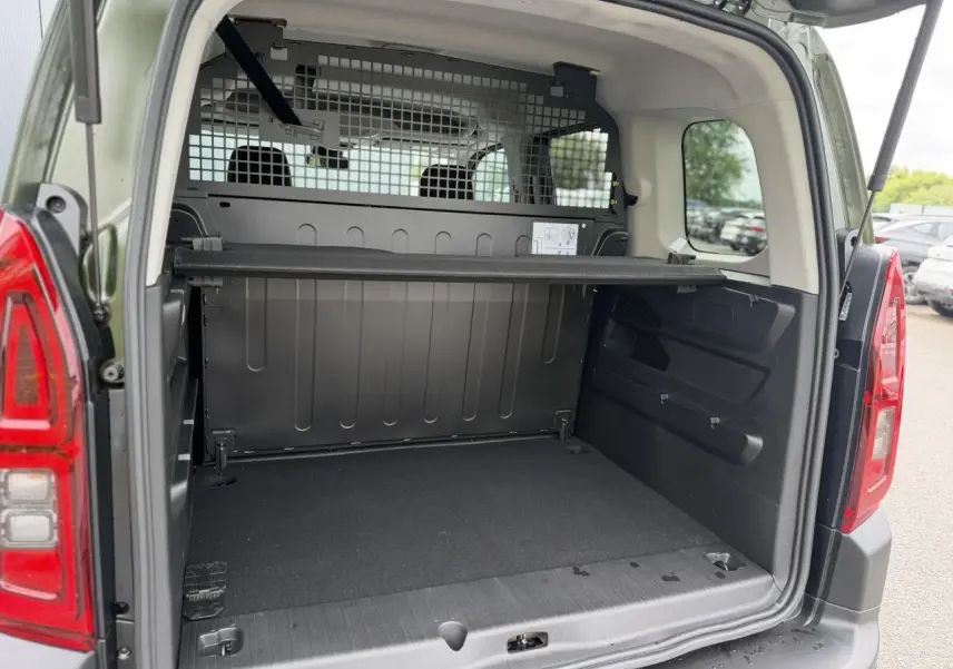 Vue arrière ouverte du Citroën Berlingo Multispace vert Sirkka montrant le coffre spacieux avec séparation rigide noire.